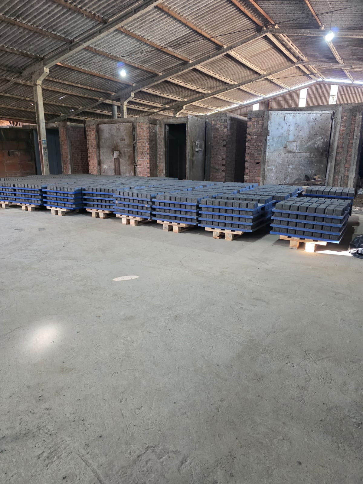 Galpão da Grifo Artefatos em Irati-PR com pallets de pisos intertravados prontos para entrega